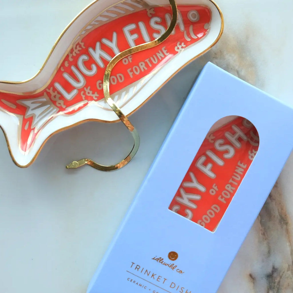 Ceramic fish-shaped dish with 'Lucky Fish' text on a marble surface