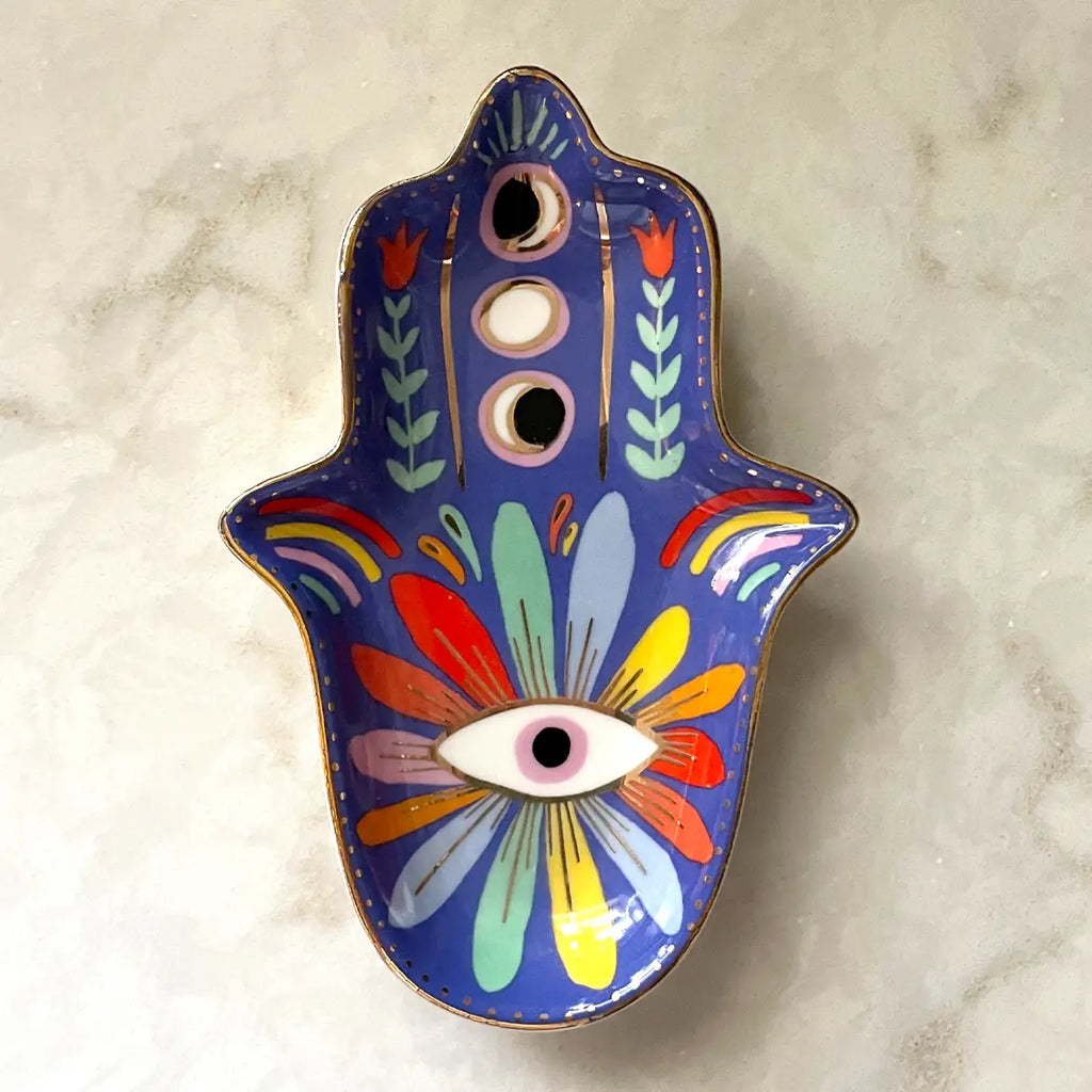 Decorative Hamsa-shaped object with colorful designs on a marble surface