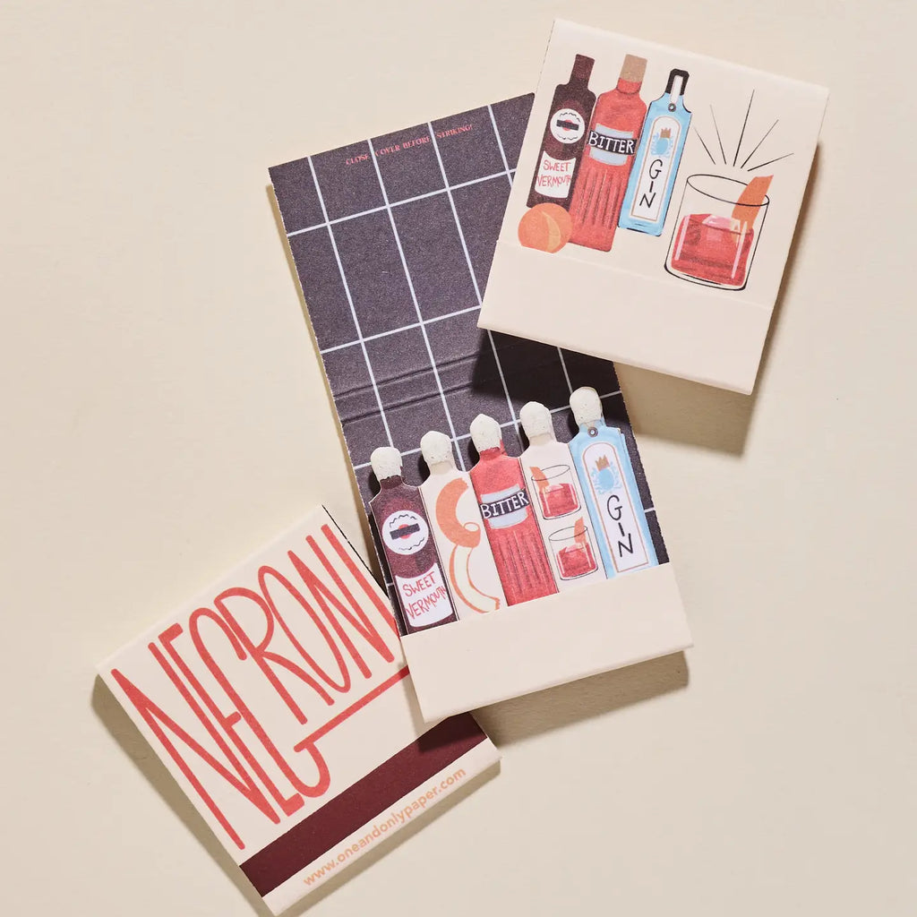 Set of miniature bottle matches with labels and a box on a beige background